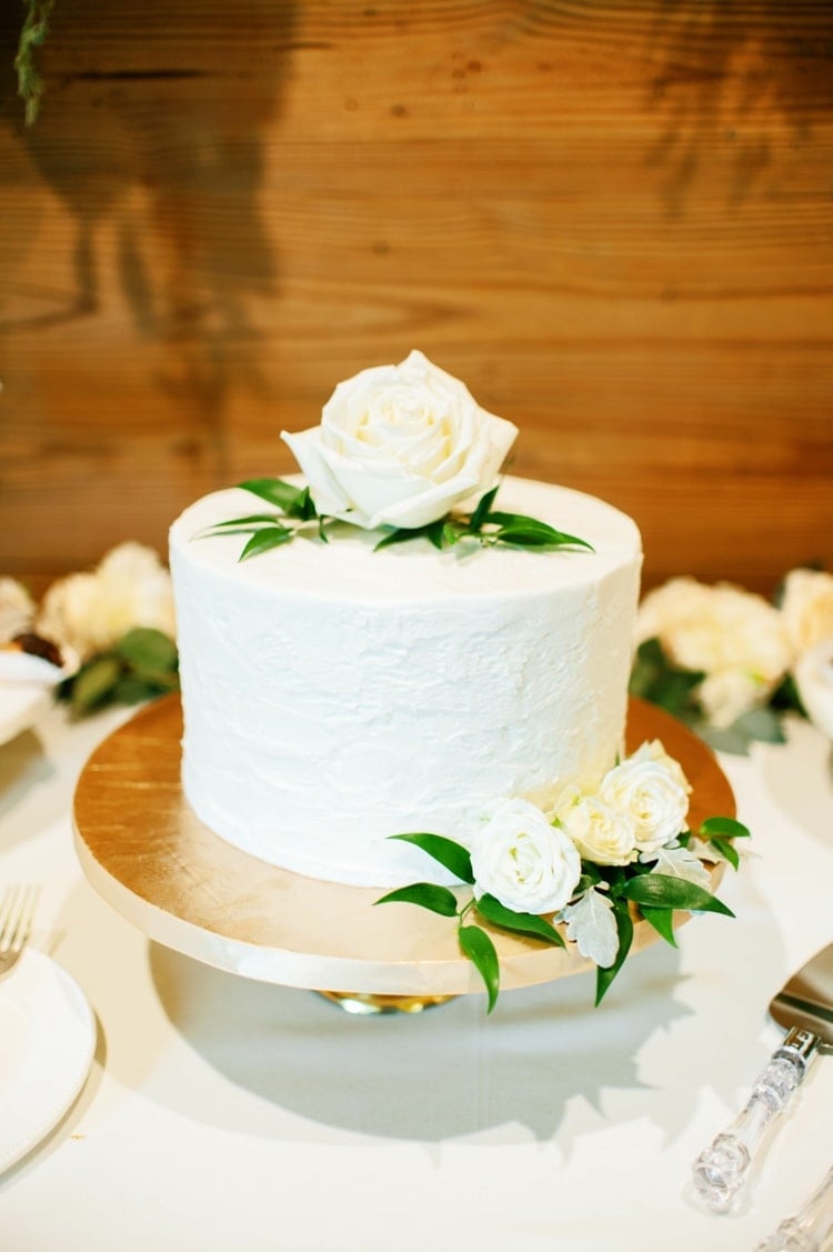 Minimalistische Hochzeit feiern mit einstöckiger Torte und weißen Rosen