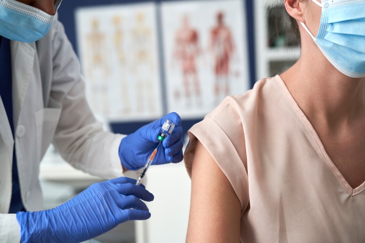medizinischer angestellter bereitet impfung gegen coronavirus für patientin vor