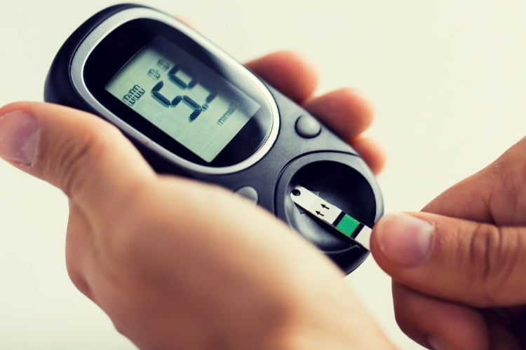 patient mit übergewicht und diabetes kontrolliert seine werte mit blutzuckemessgerät