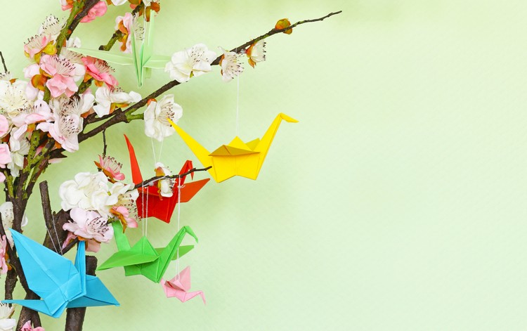 Frühlingsdeko mit Origami Kranichen und blühenden Zweigen