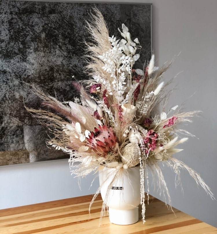 Gräser und Trockenblumen in einer Vase stecken und arrangieren
