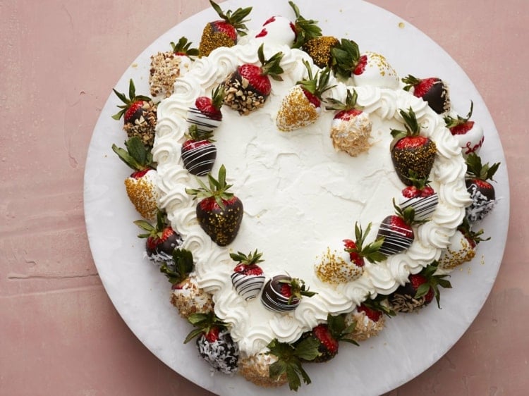 Kuchen in Herzform mit Sahne dekorieren und Erdbeeren in Schokolade