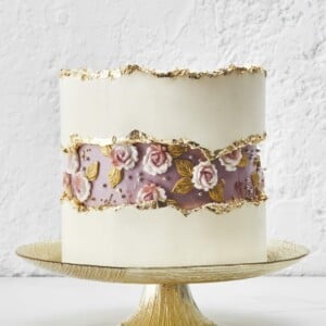 Romantischer Fault Line Cake mit essbaren Rosen und Verzierung in Gold