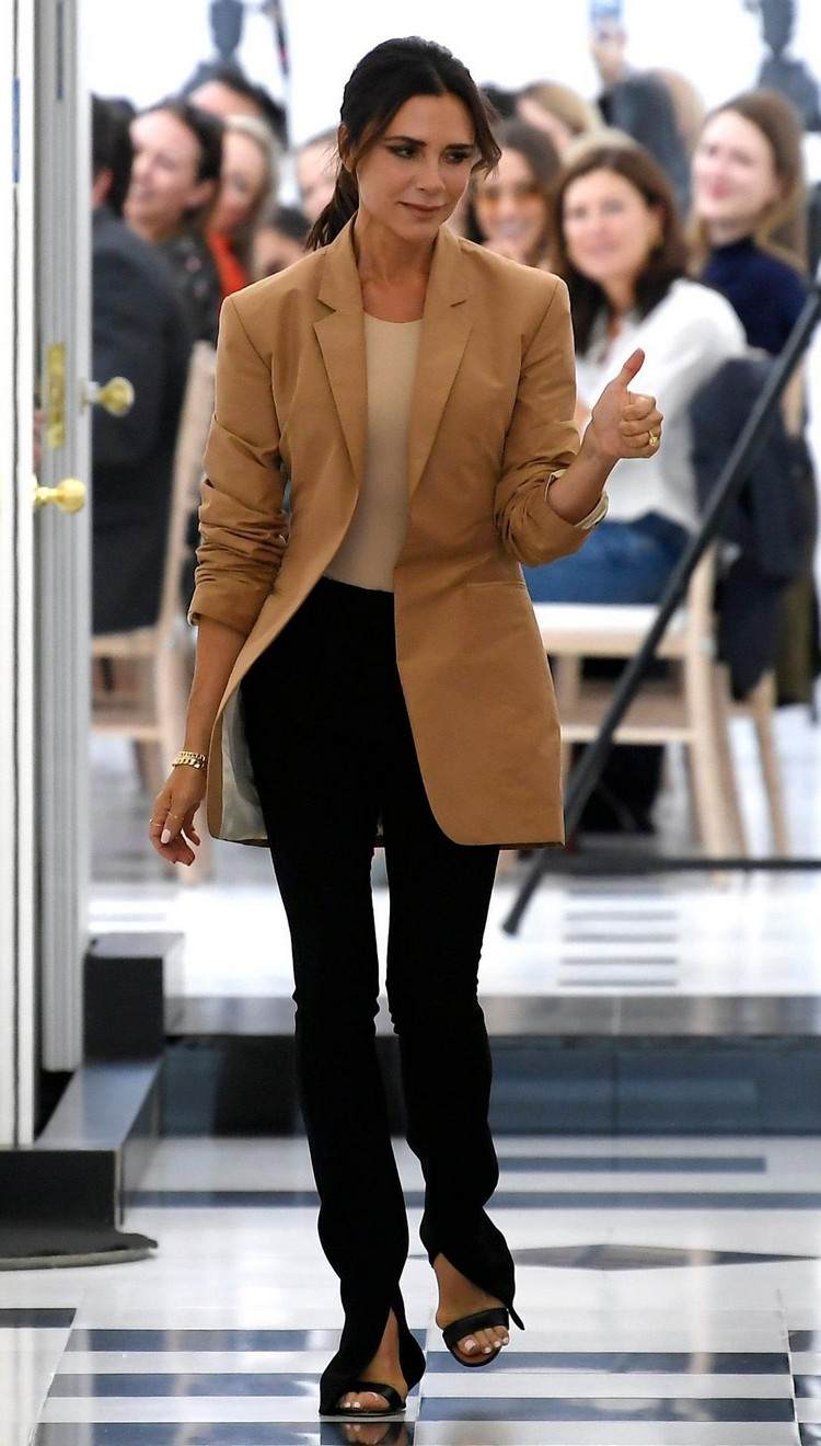 Victoria Beckham mit schwarzer geschlitzter Hose und braunem Oversize Blazer