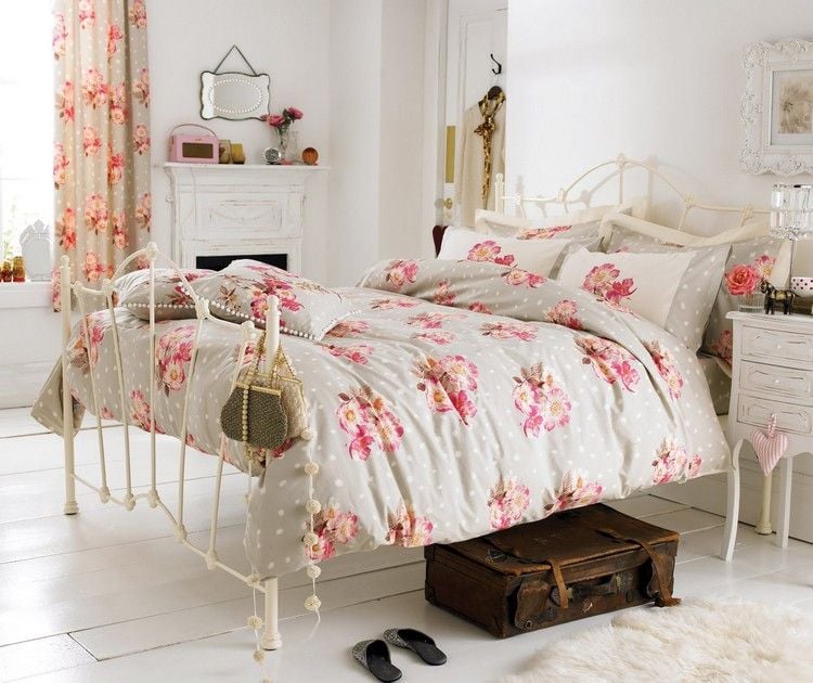 Vintage Bettwäsche mit Blumenmuster auf weißem Metallbett