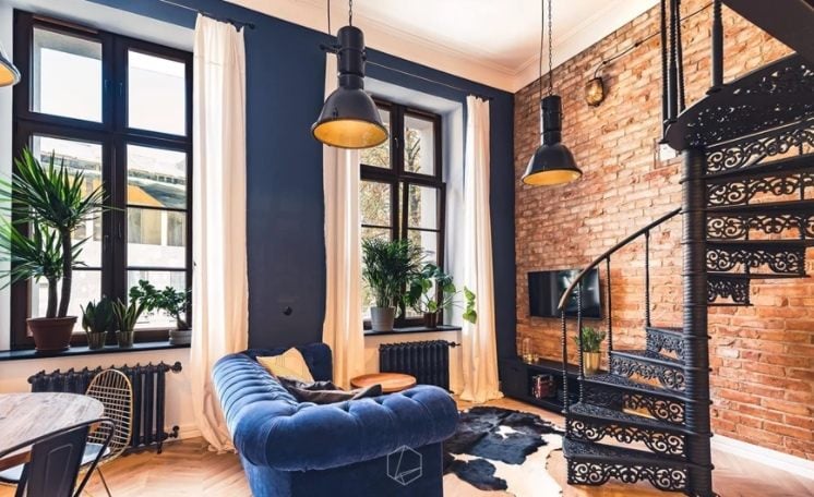 blaues Chesterfield sofa in einem wohnzimmer mit industrial flair