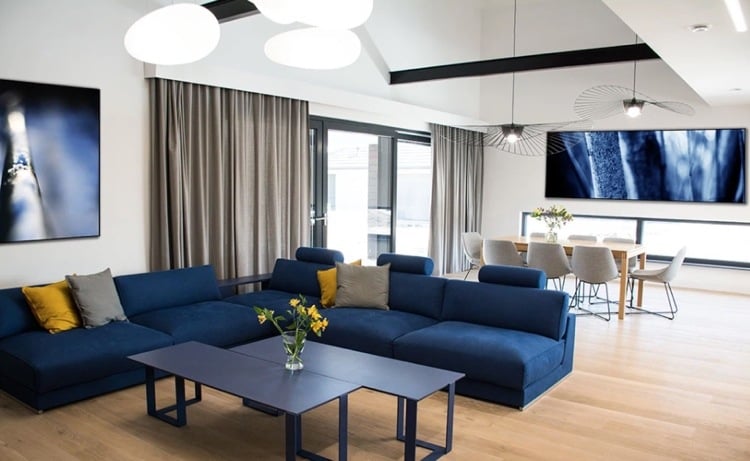 blaues sofa im modernen wohnzimmer mit kissen in grau und gelb kombiniert