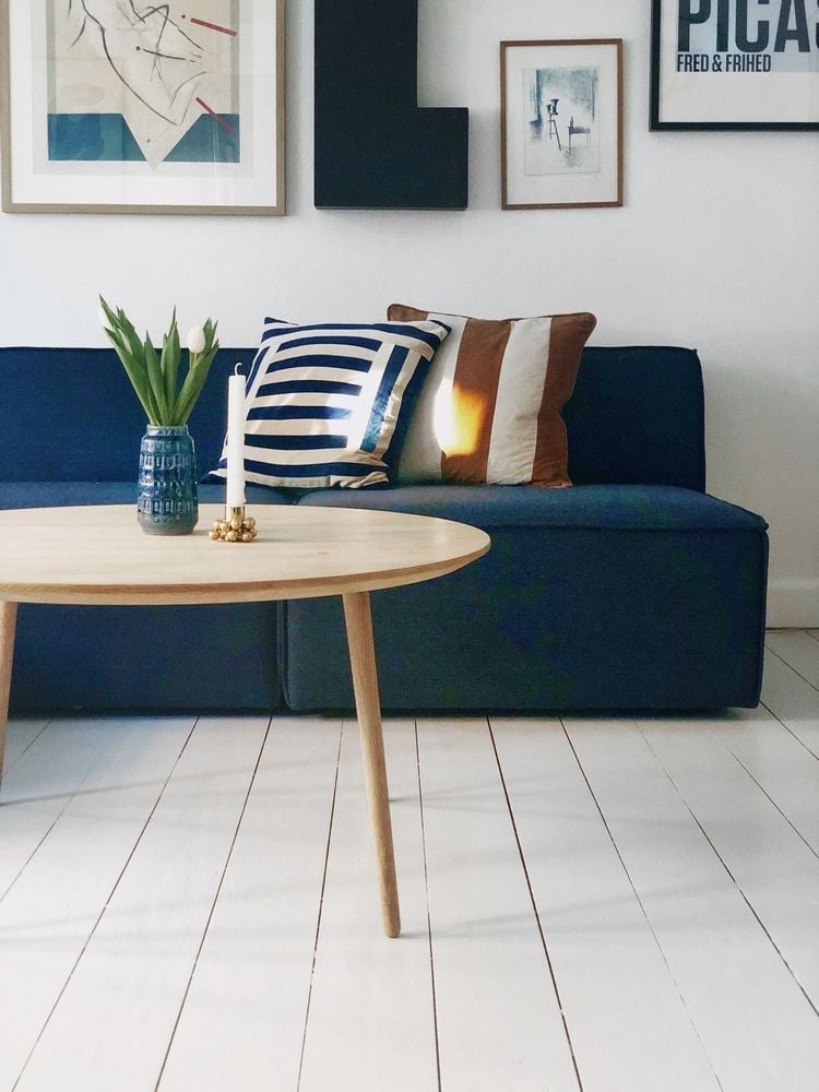 blaues sofa skandinavisch mit weißer wandfarbe und weißem dielenboden