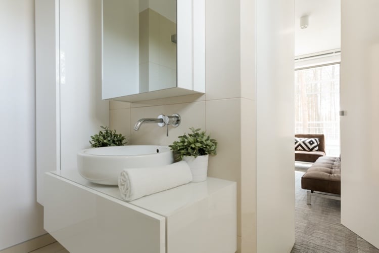 kleines Badezimmer mit Spiegelschrank rundes Aufsatzwaschmecken und beige Wandfliesen