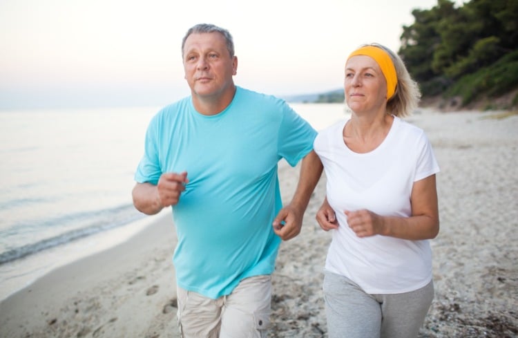 mann und frau in höherem alter machen regelmäßige bewegung wie joggen am strand