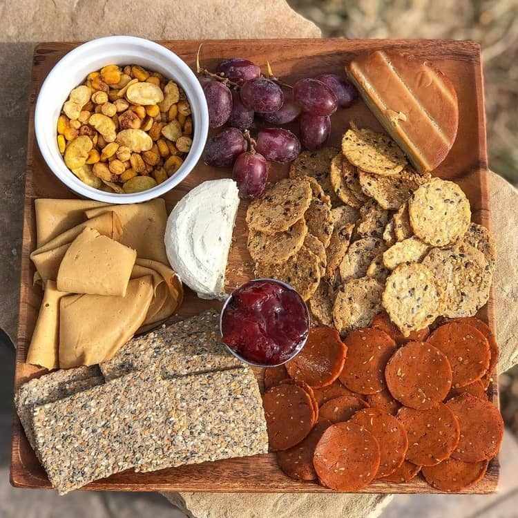 vegane Snack Platte mit Seitan Käse Cracker und Nüssen