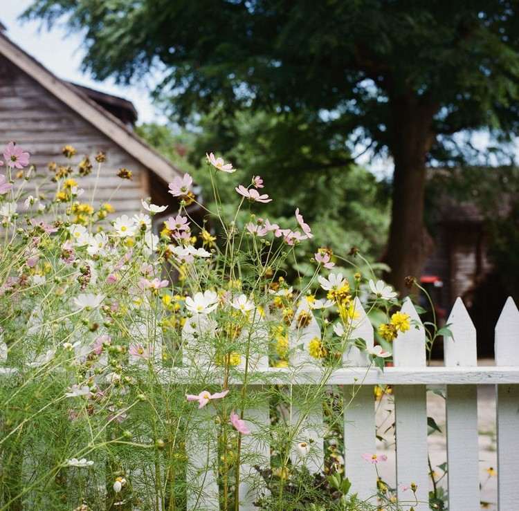 Blumenbeet neben dem Gartenzaun anlegen im Landhausstil
