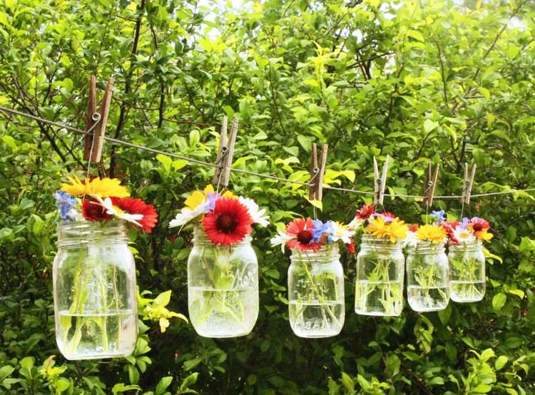 Frühlingsdeko außen auf dem Balkon Wäscheleine mit Vasen aus Gläsern