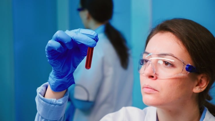 forscherin analysiert blutprobe im labor