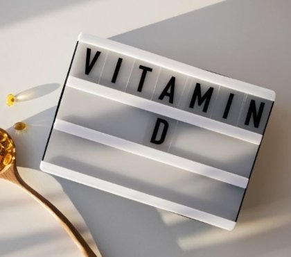 kapseln von vitamin d in fischöl neben schild unter sonnenstrahlen