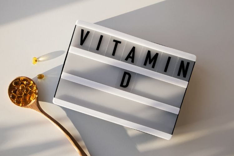 kapseln von vitamin d in fischöl neben schild unter sonnenstrahlen