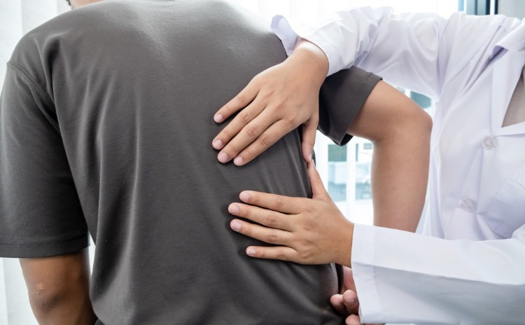 männlicher patient mit rückenschmerzen wird von einem spezialisten behandelt