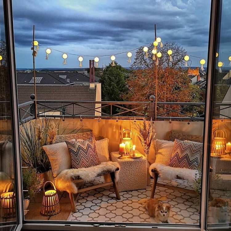 Balkon im Boho Stil mit zwei Sesseln und stimmungsvollen Leuchten