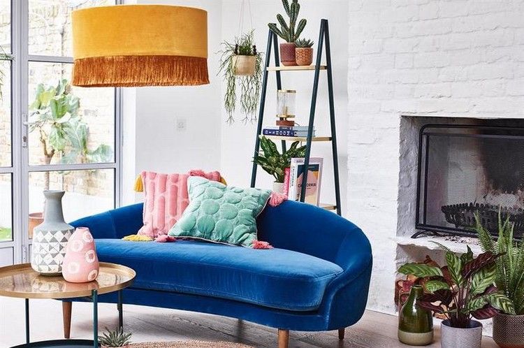 Blaues Sofa mit abgerundeter Form im modern eingerichteten Wohnraum