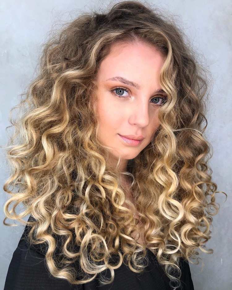 Blonde Strähnchen auf hellblondem lockigem Haar
