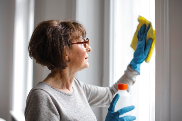 Frau über 50 beim Fensterputzen