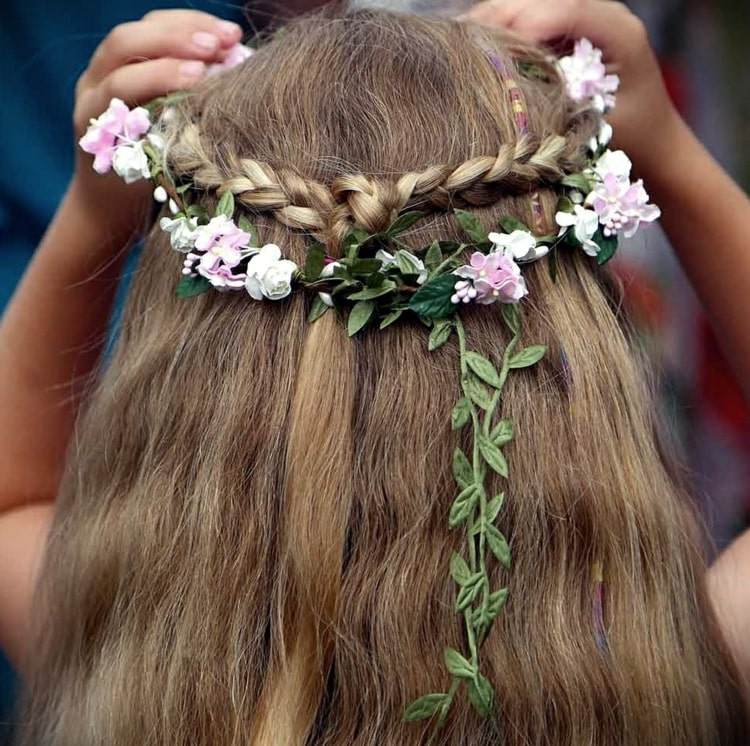 Halboffene Frisur mit Blumenkranz für einen femininen und niedlichen Look