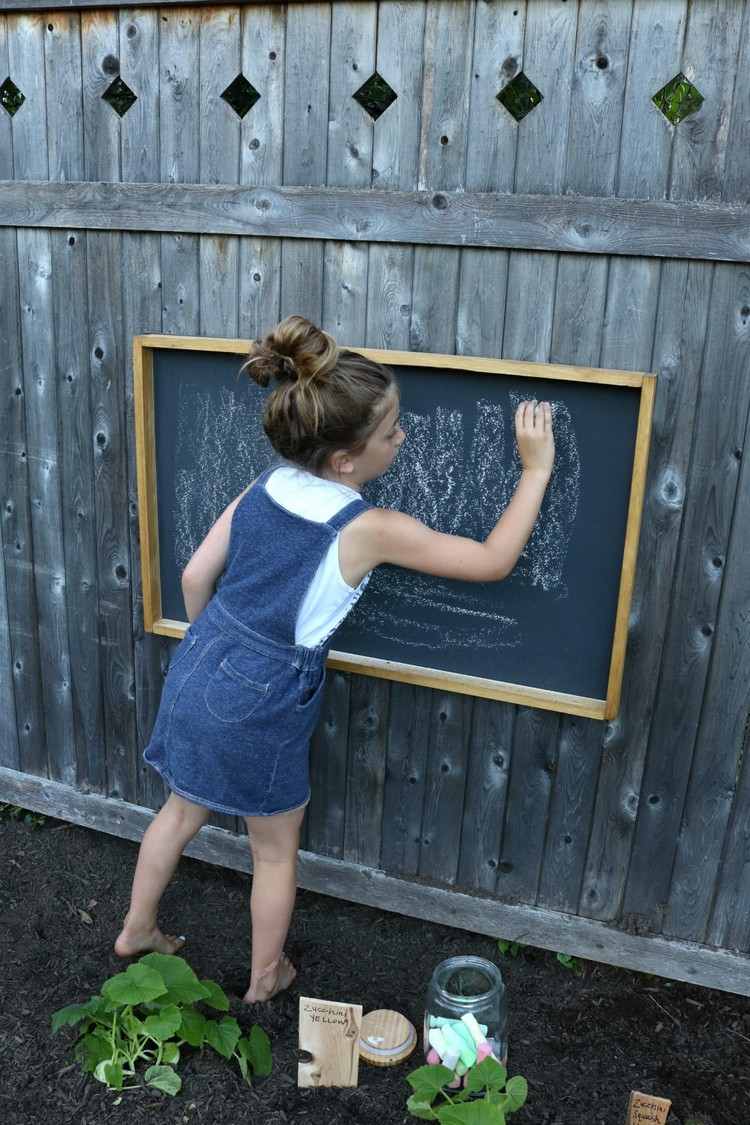 Kreidetafel für Kinder im Garten vor ersten Gebrauch mit Kreide streichen