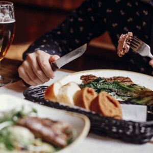 Mann isst Steak mit Grünkohl Beilage