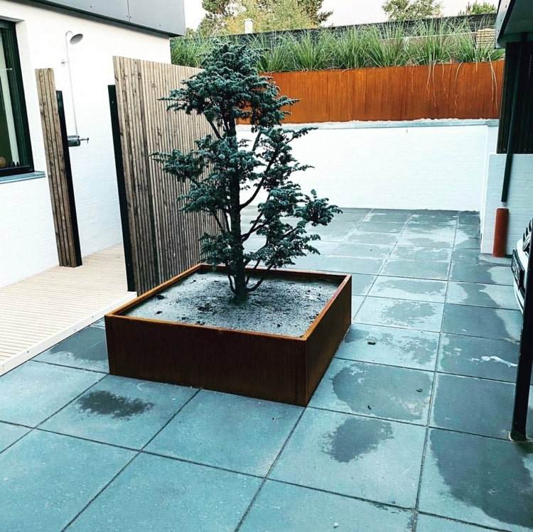 Cortenstahl Hochbeet mit Baum als Akzent für eine moderne Terrasse mit grauen Bodenplatten