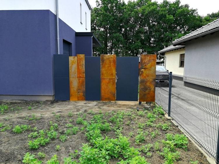 Cortenstahl Sichtschutz für ein modernes Haus mit dunkelblauen Platten