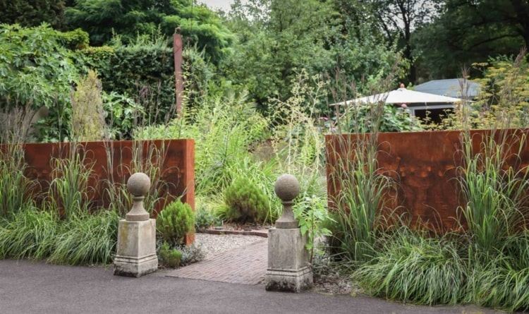 Cortenstahl Sichtschutz im klassischen Garten als moderner Akzent
