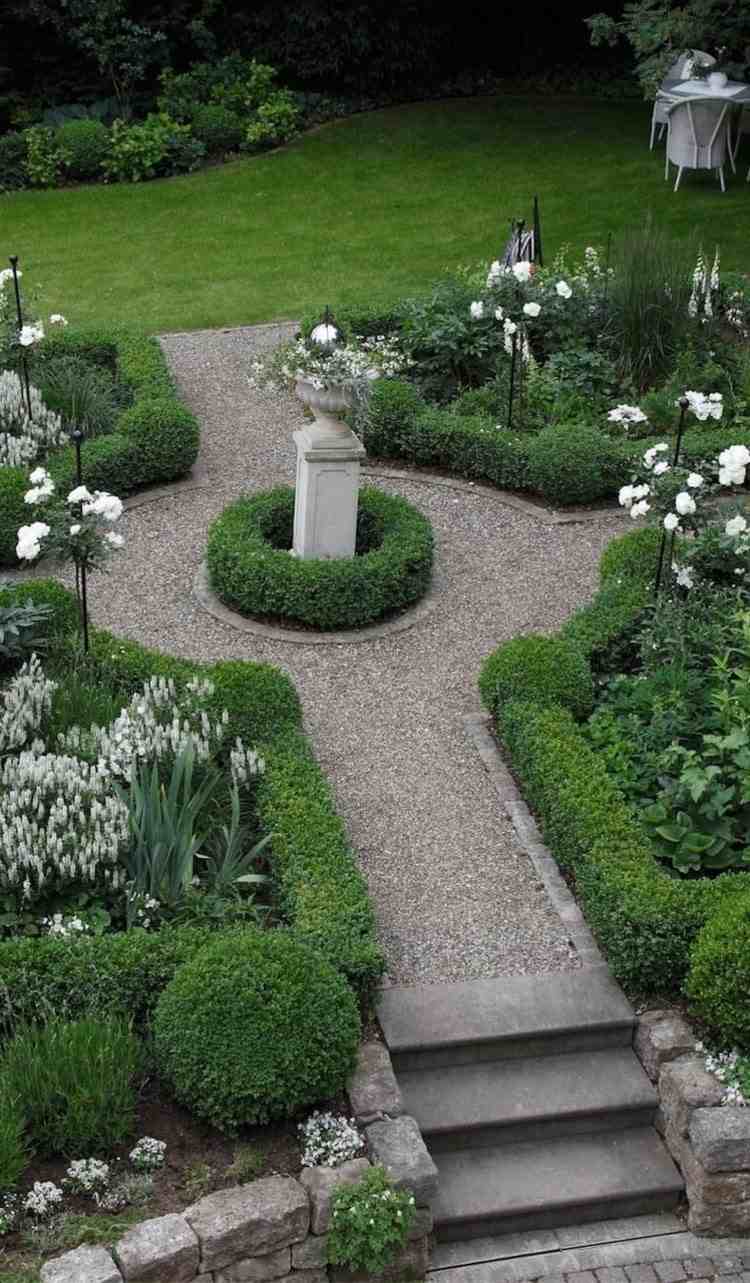 Formeller Garten mit grünen und weiß blühenden Pflanzen
