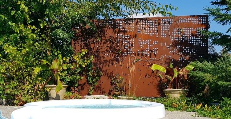 Moderner, perforierter Cortenstahl Sichtschutz für den Pool im Garten