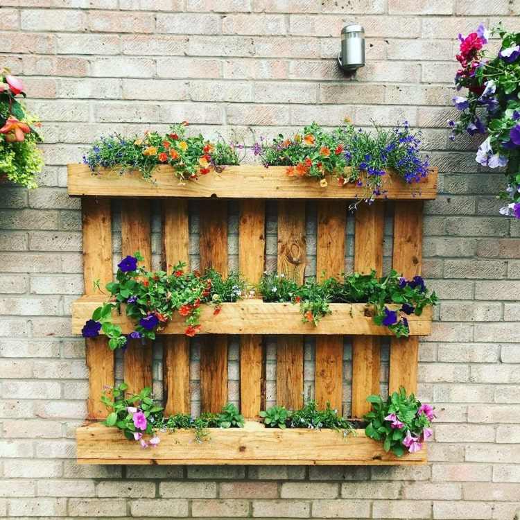 Regal zum Bepflanzen mit Balkonblumen aus Holzpaletten für die Wand