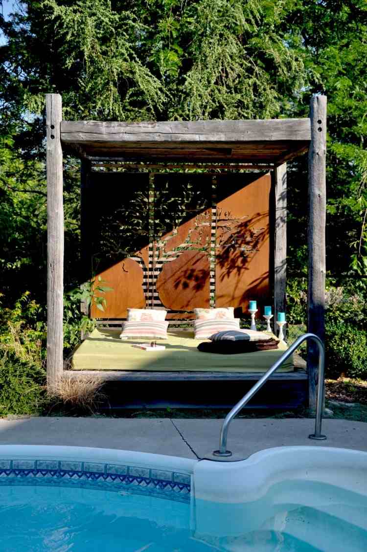 Sichtschutzidee für ein Tagesbett aus Holz am Poolbereich mit Motiven