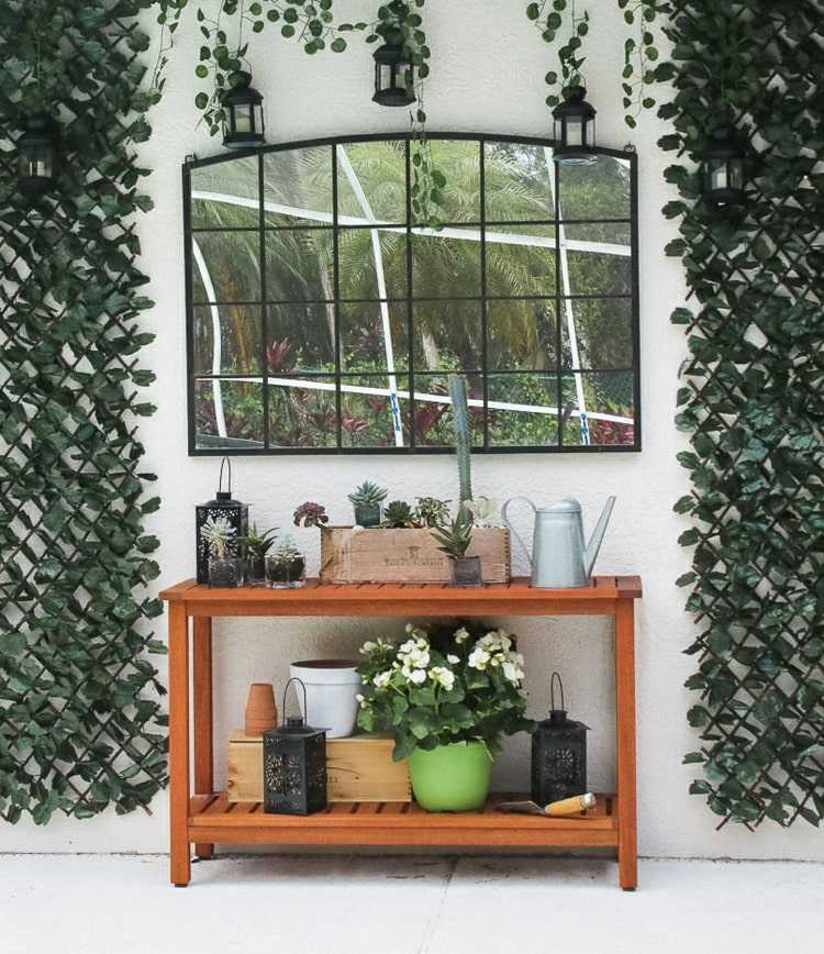 Spiegel auf der Terrasse mit Beistelltisch für Pflanzen und Dekorationen und Rankgitter