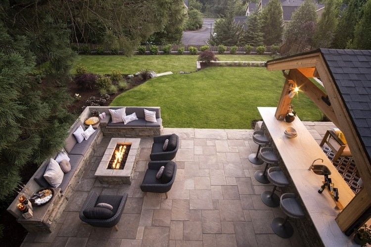 Terrassenlounge mit Feuerstelle gegenüber Gartenbar
