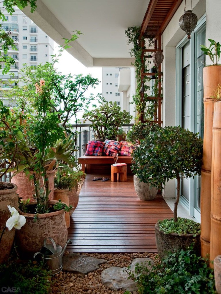 Balkon Gestaltung klein mit Pflanzen und Holzboden und Kies