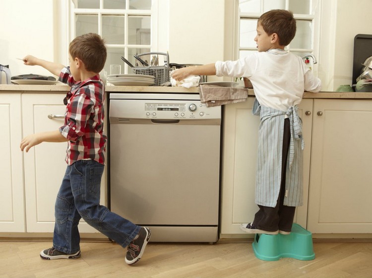 Kinder putzen die Küche