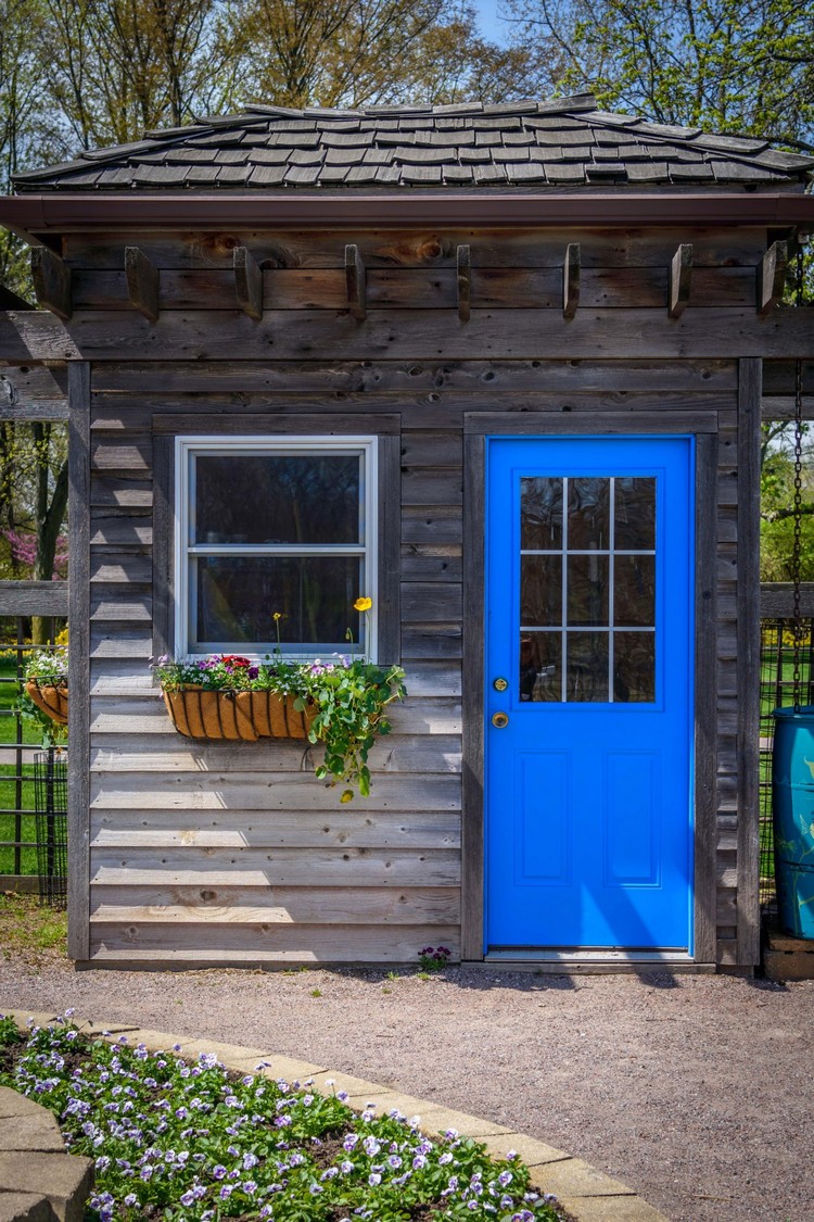 Rustikales Gartenhaus mit blau gestrichener Tür