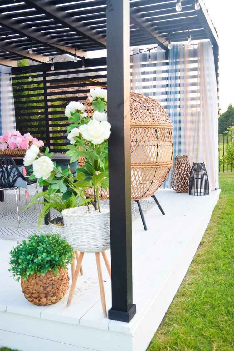 Überdachte Terrasse im Sommer dekorieren mit Blumen und Vorhängen