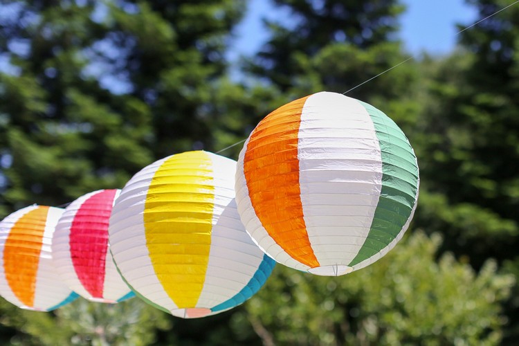 Sommerfest Deko selber machen bunte Strandbälle aus Papierlampions aufhängen