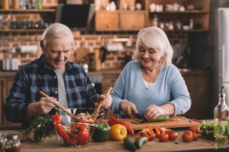älteres paar verwendet buntes gemüse für salat gegen demenz