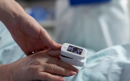 arzt kontrolliert niedrige hämoglobinwerte von älteren patientin mit oximeter