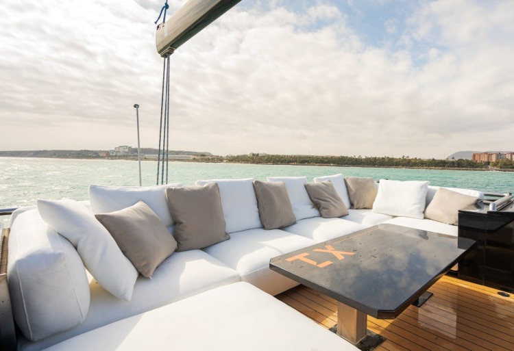 lounge bereich mit ecksofa und kissen auf dem deck einer trimaran yacht.