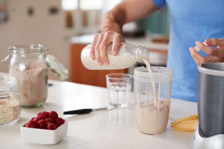 mann bereitet ein proteinreiches frühstück zur förderung vom muskelaufbau zu