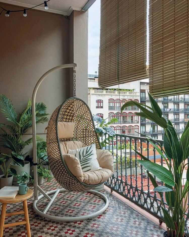 tropischer balkon mit großen pflanzen und hängesessel