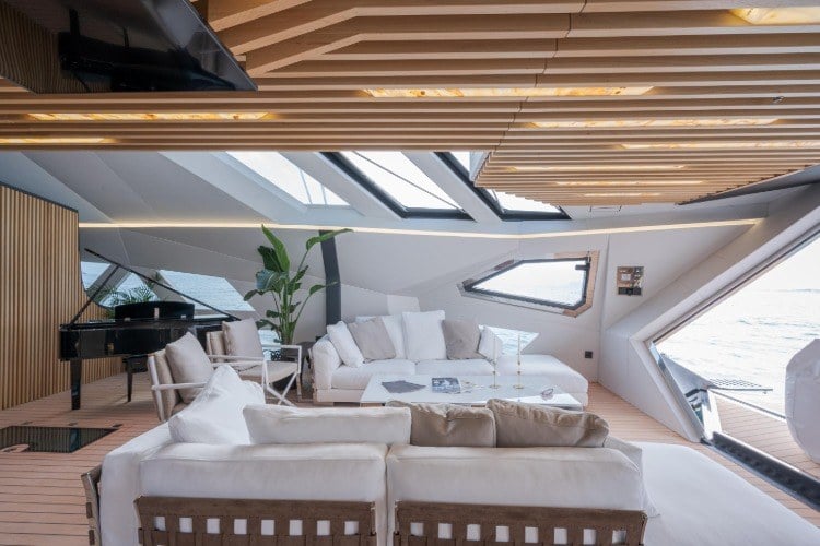 wohnzimmer der extraklasse mit royal und weißer couch auf dem bord einer trimaran yacht mit holzdecken