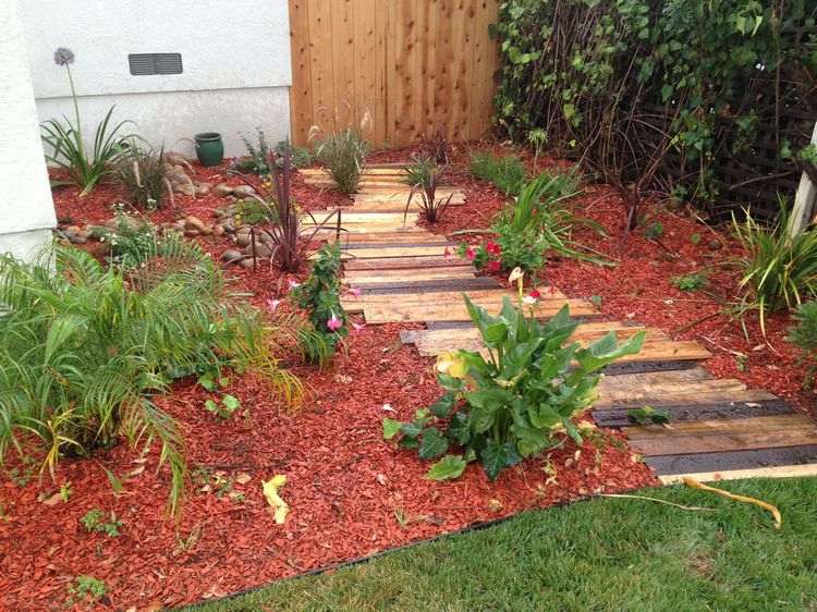 DIY Gartenweg aus Altholz auf rotem Mulch