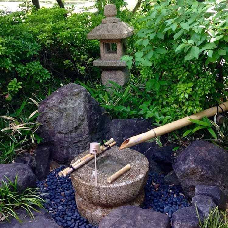 Japanisches Wasserspiel mit Felsen, Kieselsteinen und Bambus